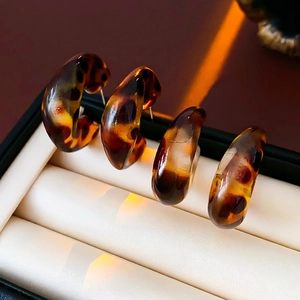 Set of four tortoise shell resin C-shaped earrings elegantly displayed in a jewelry box