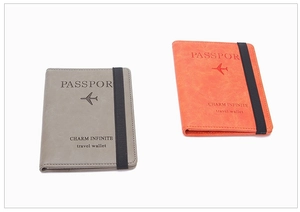 Detailed view of grey and orange textured leather passport covers with secure elastic straps