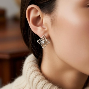 Close-up of geometric hollow zircon earrings worn by a model in a vintage luxury style