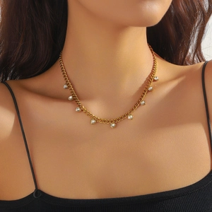Close-up of gold stainless steel necklace with clear crystal heart charms on a model