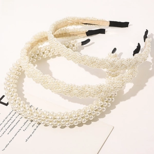 Detailed view of three-piece pearl headbands with light gold metal frame and black tips