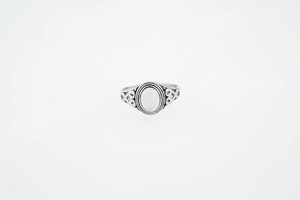 Detail of vintage steel ring featuring white oval stone and Celtic knot patterns