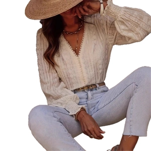 Detail of white lace embroidery and V-neckline on this elegant long sleeve shirt