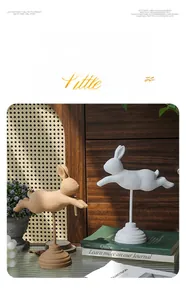 Détail de statues de lapins en bois sur supports avec finitions blanc et naturel