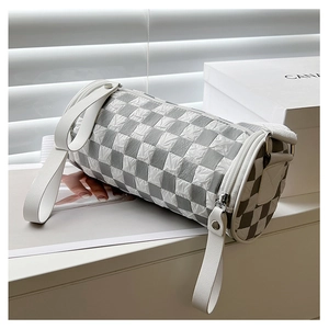 Detail of the checkered barrel bag showing the pleated texture and white leather strap