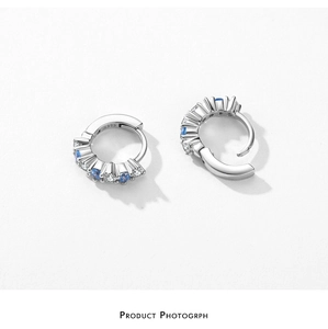 Detailed macro of S925 sterling silver hoop earrings with white and blue zircon inlay
