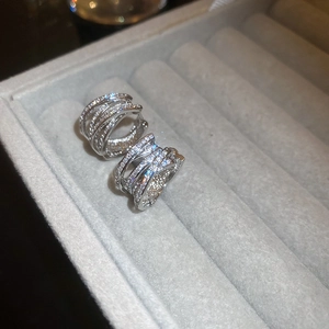 Macro shot of silver multi-layer crisscross earrings set with sparkling zircon stones