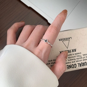 Detail of 925 sterling silver ring with black cross stone worn on a finger