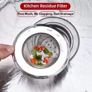 Detail of a wide-rim stainless steel sink strainer filtering food waste under running water