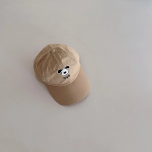 Detailed close-up of khaki kids baseball cap with cute cartoon dog embroidery and black DOG text