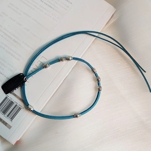 Close-up of peacock blue velvet cord with vintage silver alloy beads and U-clip for hair