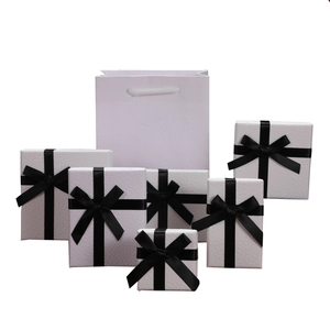 Elegant white textured jewelry gift box set with black ribbon bows and matching paper bag