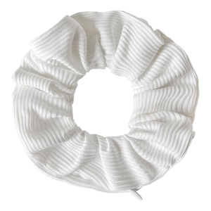 Detailed view of white tie-dye velvet hair scrunchie showing striped texture and small label