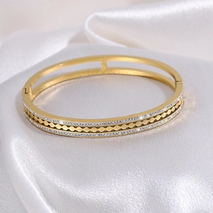 Detailed macro view of gold-plated stainless steel bangle with hollow design and rhinestones