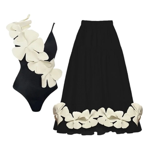Black V-neck one-piece swimsuit set with large white 3D floral appliques and skirt