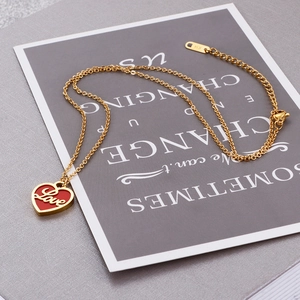 Détail du collier doré en acier K14 avec pendentif cœur Love rouge sur carte esthétique
