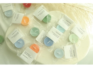 Colorful tealight candles with clear packaging displayed in a cozy home setting