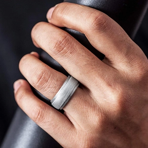 Macro shot of a matte silver-grey silicone athletic ring for men on a textured hand grip
