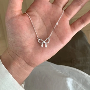 Close-up of a silver butterfly pendant necklace with delicate beaded chain detail