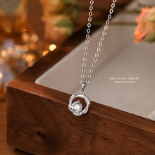 Macro detail of S925 sterling silver ring pendant on a wooden jewelry box with bokeh light