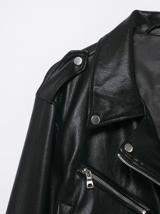 Detail of black motorcycle jacket with notch lapels, metal zippers, and shoulder epaulettes