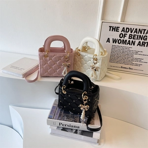 Quilted crossbody bag in pink, white, and black with pearl and bow charms