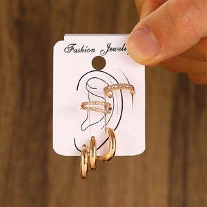 Detail of gold ear piercing set with white cubic zirconia on a jewelry display card