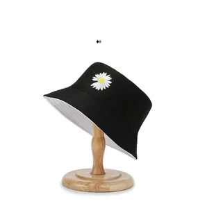 Detail of black cotton bucket hat featuring white daisy embroidery and contrasting inner