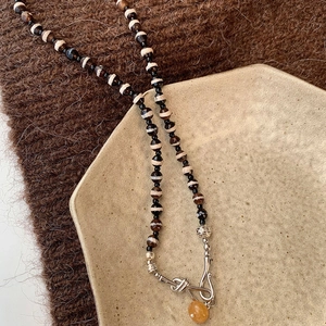 Collier ethnique avec perles noires et blanches et pendentif en agate naturelle