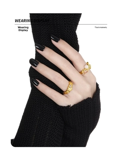 Detail view of irregular gold lava texture rings with pearl and gemstone on hand