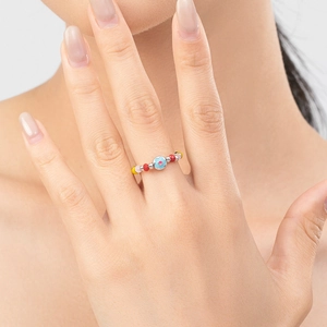 Anello con perline colorate in argento S925 con fiore blu indossato dal modello sul dito