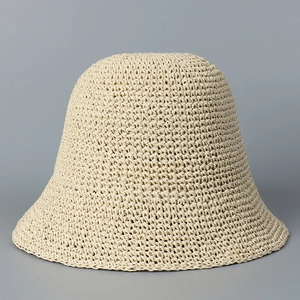 Detailed close-up showing the fine handmade weaving texture of the beige straw bucket hat