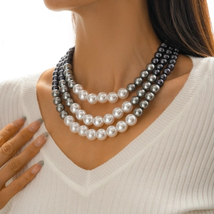 Detailed view of triple-layer pearl necklace in gradient white, grey and black tones