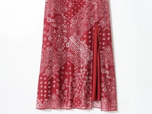 Detailed view of red paisley print dress with a high side slit and soft chiffon texture