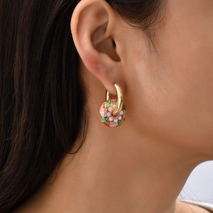 Detailaufnahme der roten Emaille-Blumenohrringe mit Goldring an einem weiblichen Model