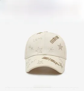 Close-up of gold star and lettering embroidery on cream cotton baseball cap details