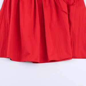 Détail de l'ourlet de la robe rouge sans manches avec coutures et tissu de haute qualité