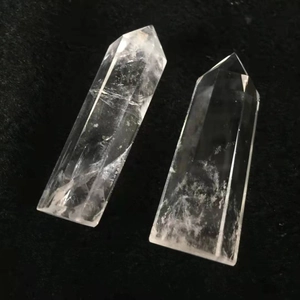 Polished natural clear quartz hexagonal prisms with natural ice cracks on black background