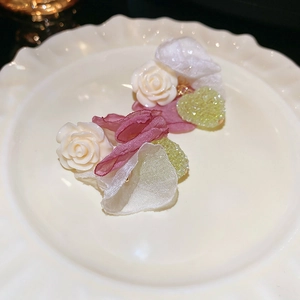 Detail of floral heart earrings with pink satin petals and resin rose crystals