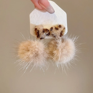 Detail of S925 silver needle earrings with khaki pom-poms and leopard print design