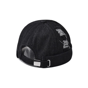 Detailed view of distressed black denim docker cap with retro frayed holes and metal buckle