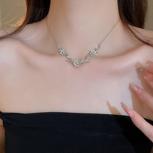 Detail of silver floral necklace with zircons worn on model's collarbone