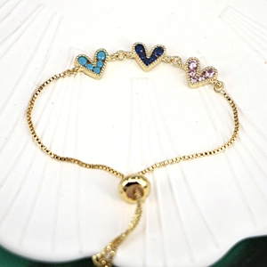 Detail of adjustable gold box chain with three colorful heart-shaped zircon charms