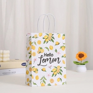 White kraft paper shopping bag with yellow lemon prints and twisted paper handles