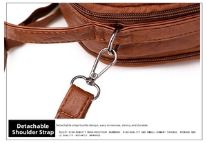 Detail view of the detachable shoulder strap with metal hooks on a brown vintage bag