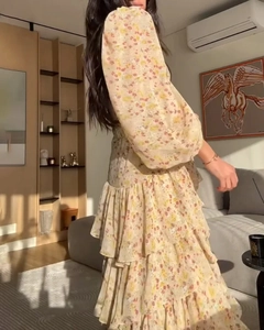 Détail de la robe fleurie jaune avec manches bouffantes et jupe à volants étagés