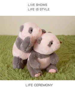 Detail of two cute plush panda cubs in soft pink and gray long-pile fluffy faux fur