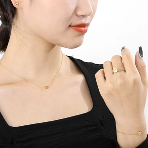 Detailed view of gold jewelry set with cat paw motifs on necklace and bracelet