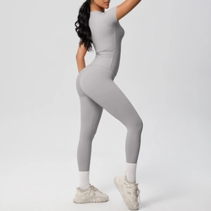 Side view of woman in light gray short sleeve yoga top and high waist leggings set