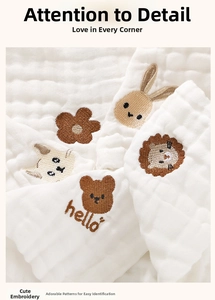 Detail of layered cotton baby washcloths featuring cute animal and floral embroidery